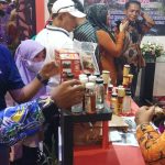Salah seorang kontingen sedang menanyakan produk dari Kabupaten Merauke yang dipamerkan – Surya Papua/Frans Kobun