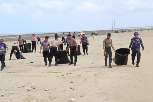 Anggota polisi di Polairud bersama warga setempat membersihkan Pantai Lampu Satu, Kelurahan Samkai – Surya Papua/Frans Kobun