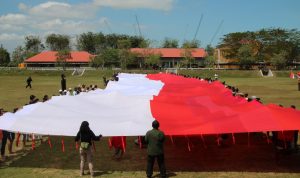 Bendera Merah Putih berukuran raksasa dibentangkan di Monumen Kapsul Waktu – Surya Papua/Frans Kobun