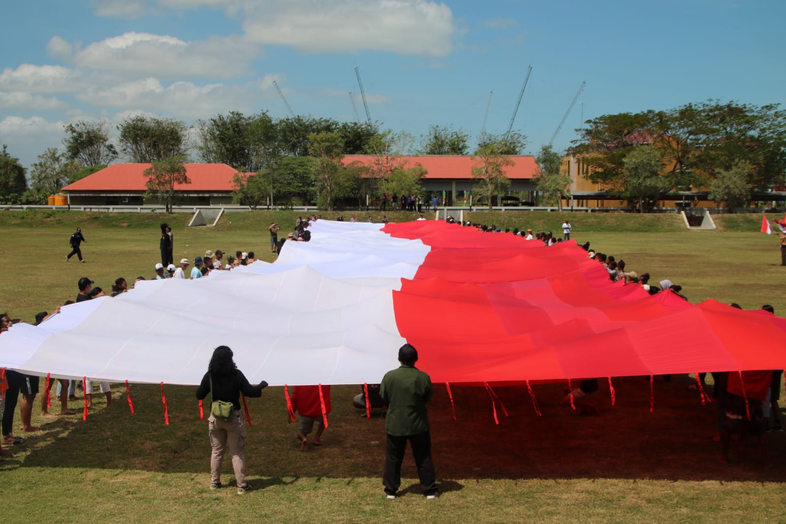 Bendera Merah Putih berukuran raksasa dibentangkan di Monumen Kapsul Waktu – Surya Papua/Frans Kobun