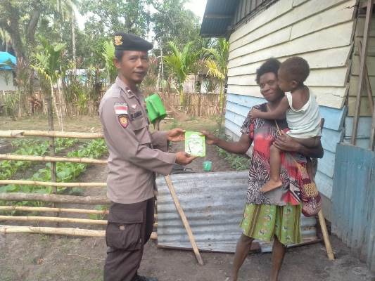 Aipda Bawa Santoso, Bhabinkamtibmas Kampung Kimaam sedang memberikan bantuan bibit sayur – Surya Papua/IST