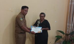 Kepala Kesbangpol Kabupaten Merauke, Rama Dayanto sedang menyerahkan cinderamata kepada seorang pensiunan – Surya Papua/Frans Kobun