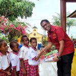 Perwakilan TSE Group sedang berjabatan tangan dengan anak-anak di Kampung Asiki, Kabupaten Boven Digoel – Surya Papua/IST