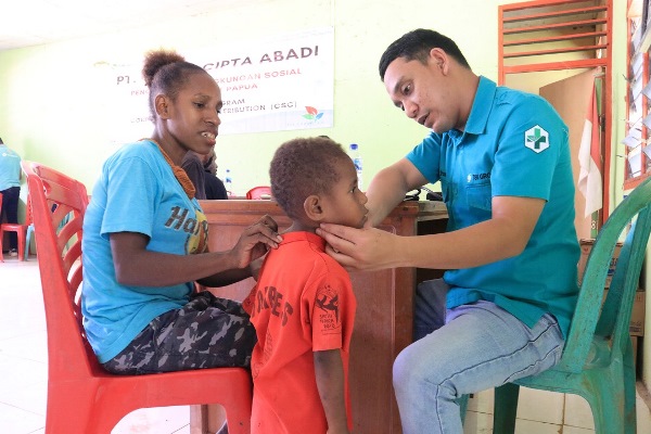 dr. Rizal Irsan sedang melakukan pelayanan kesehatan kepada seorang anak - Surya Papua/IST