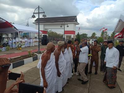 Bupati Merauke, Romanus Mbaraka sedang mengalungkan peserta umroh – Surya Papua/Frans  Kobun