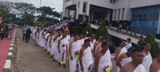 Para calon Jemaah umroh yang meneteskan air mata saat sedang berjalan – Surya Papua/Frans Kobun