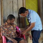 dr. Rizal Irsan sedang melakukan pemeriksaan kesehatan saat mengunjungi salah stau rumah masyarakat – Surya Papua/IST