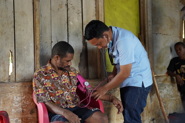 dr. Rizal Irsan sedang melakukan pemeriksaan kesehatan saat mengunjungi salah stau rumah masyarakat – Surya Papua/IST