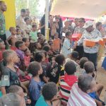 Bupati Merauke, Romanus Mbaraka sedang membagikan kue kepada anak-anak di Kampung Kaliki – Surya Papua/Frans Kobun