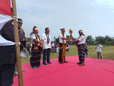 Ketua Panitia Flobamora Cup IV, Ignasius Naga Lake sedang menyerahkan piala bergilir kepada Ketua Flobamora Kabupaten Merauke, Arnoldus Moda – Surya Papua/Frans Kobun