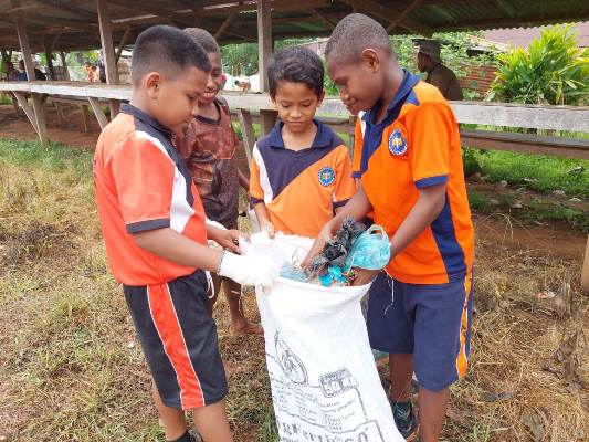 Sejumlah siswa di SD YPK Harapan Selil sedang membersihkan sampah di areal pasar – Surya Papua/IST