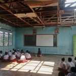 Kepsek SD YPPK Teri, Johanes Jordanus Sutawibawa saat melantai bersama anak didiknya sekaligus melaksanakan kegiatan belajar mengajar. Tampak banguan sekolah juga rusak parah – Surya Papua/IST