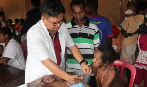 Pelayanan kesehatan yang dilakukan dr. Firman kepada salah satu masyarakat Papua – Surya Papua/IST