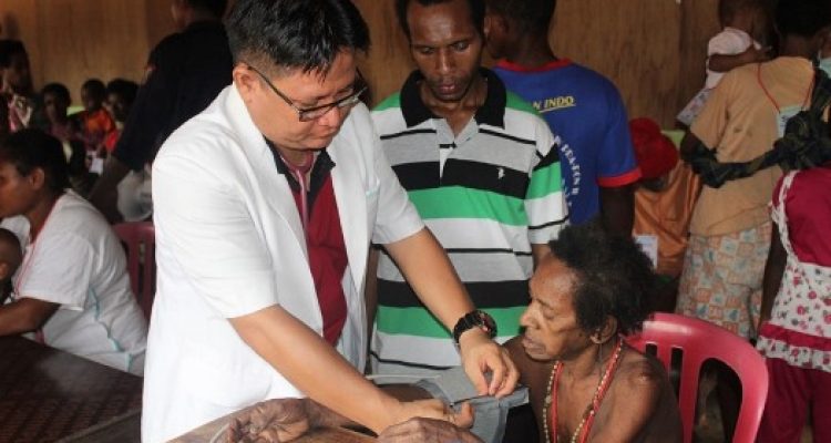 Pelayanan kesehatan yang dilakukan dr. Firman kepada salah satu masyarakat Papua – Surya Papua/IST