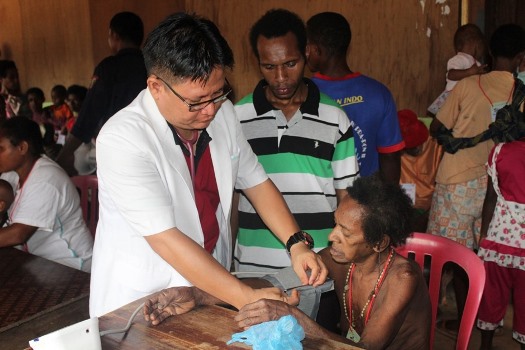 Pelayanan kesehatan yang dilakukan dr. Firman kepada salah satu masyarakat Papua – Surya Papua/IST