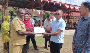 Bupati Merauke, Romanus Mbaraka sedang menyerakan piagam penghargaan kepada John Retob mewakili pimpinan TSE Group – Surya Papua/Frans Kobun