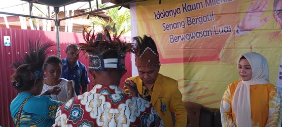 Ketua Ikatan Keluarga Waropen di Kabupaten Merauke, Efred Erari sedang mengenakan atribut kepada Caleg DPR RI dari Partai Golkar, H. Muhammad Topan Syah – Surya Papua/Frans Kobun