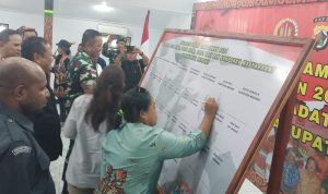Ketua KPU Kabupaten Merauke, Rosiana Kebubun sedang menandatangani spanduk saat deklarasi pemilu damai di Kodim 1707 Merauke – Surya Papua/Frans Kobun