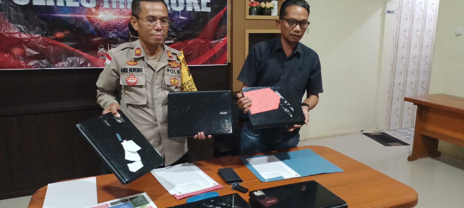 Kasi Humas Polres Merauke, Ajun Komisaris Polisi (AKP) Ahmad Nurung didampingi KBO Satreskrim Polres setempat, Ipda Sewang sedang menunjuk barang bukti laptop yang diamankan – Surya Papua/Frans Kobun