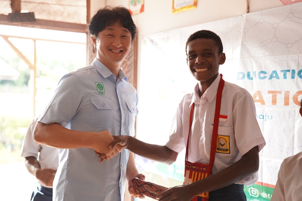 Salah seorang siswa sedang berjabatan tangan bersama salah satu pimpinan TSE Group – Surya Papua/IST