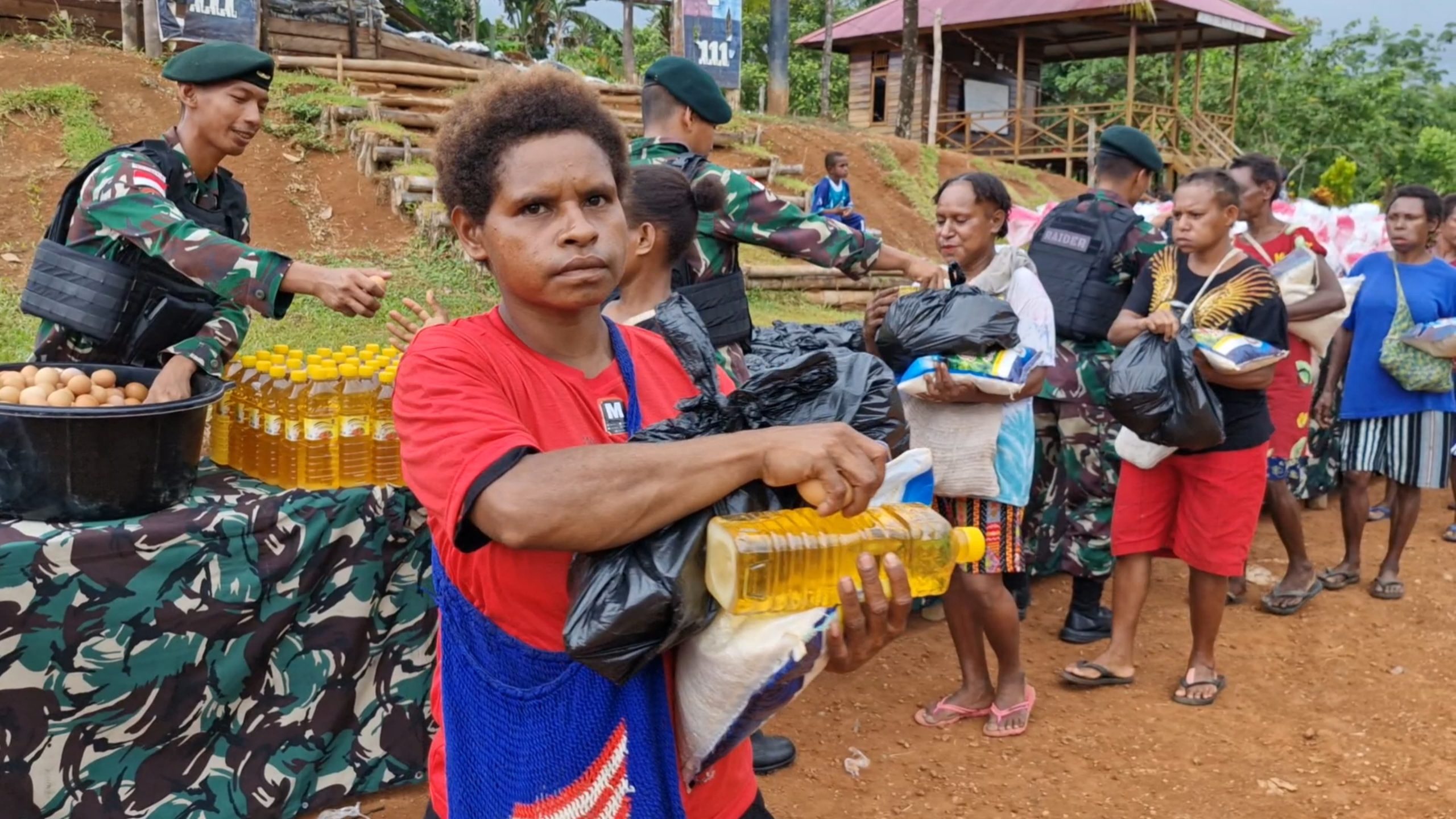 Sejumlah warga menerima sembako yang dibagikan oleh Satgas pamtas RI-PNG – Surya Papua/IST