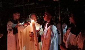 Pembakaran Lilin Paskah oleh Pastor Pius Oematan, Pr di samping gereja disaksikan ratusan umat – Surya Papua/Frans Kobun