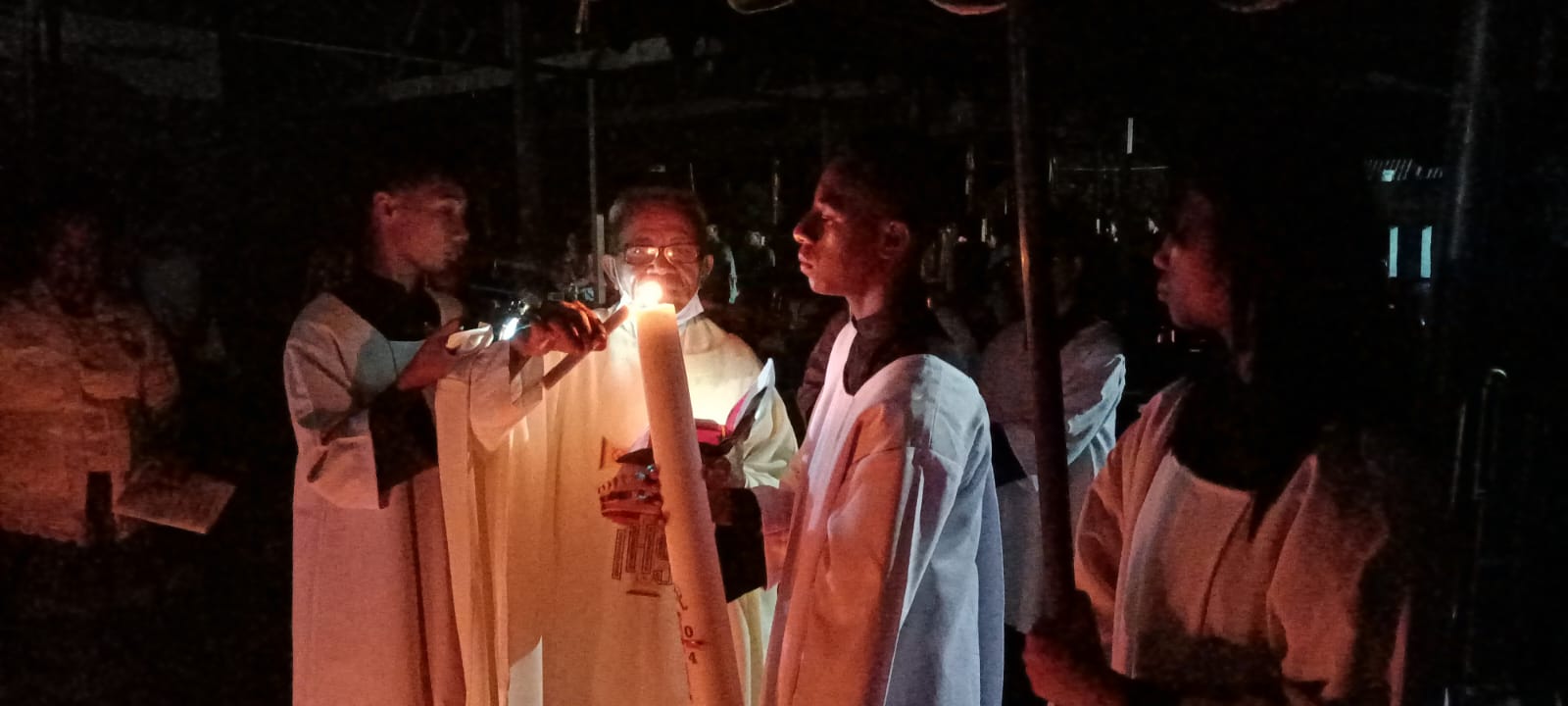 Pembakaran Lilin Paskah oleh Pastor Pius Oematan, Pr di samping gereja disaksikan ratusan umat – Surya Papua/Frans Kobun