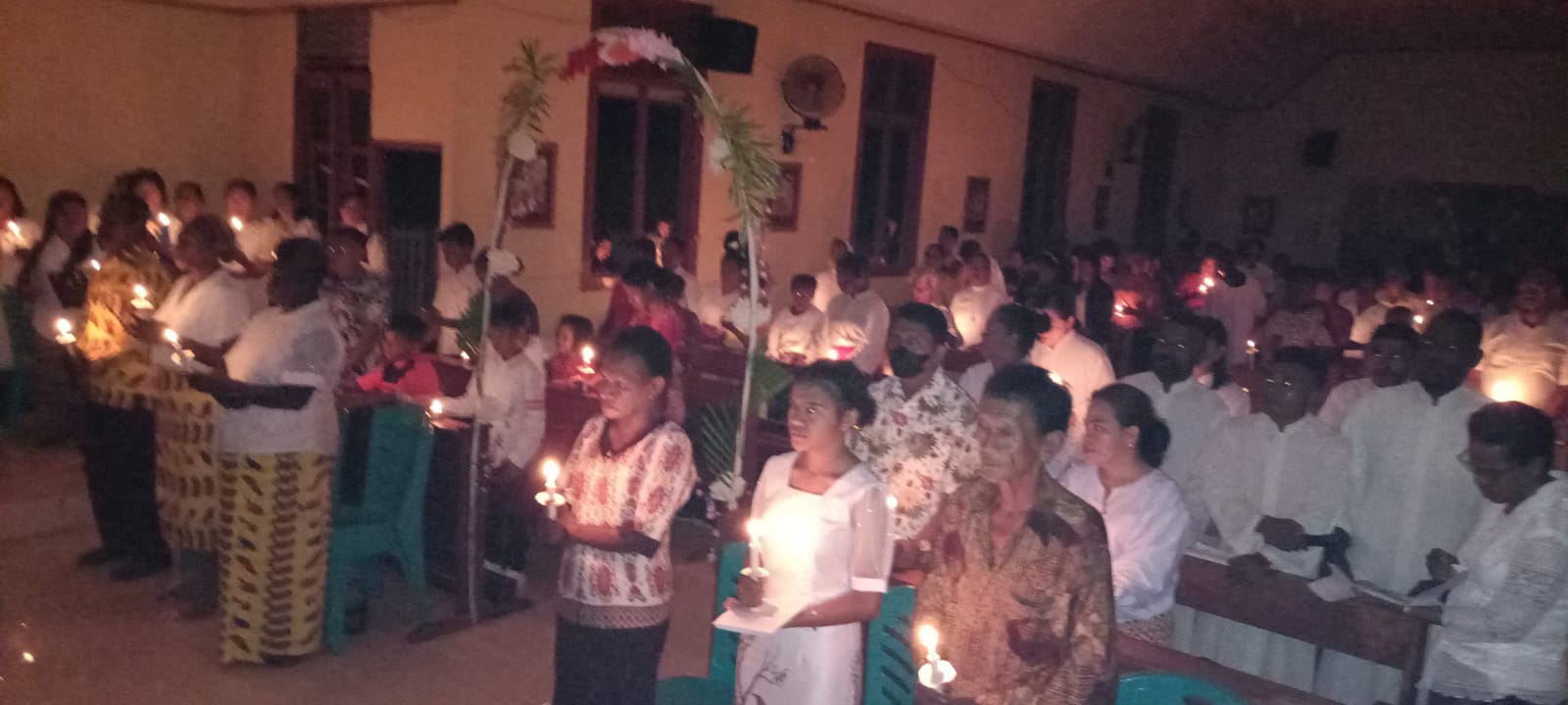 Umat sedang menyalahkan lilin yang dibawa setelah Lilin Paskah diarak – Surya Papua/Frans Kobun