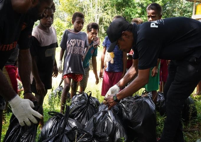 Proses pemungutan sampah yang berserakan di jalanan oleh masyarakat bersama managemen TSE Group – Surya Papua/IST