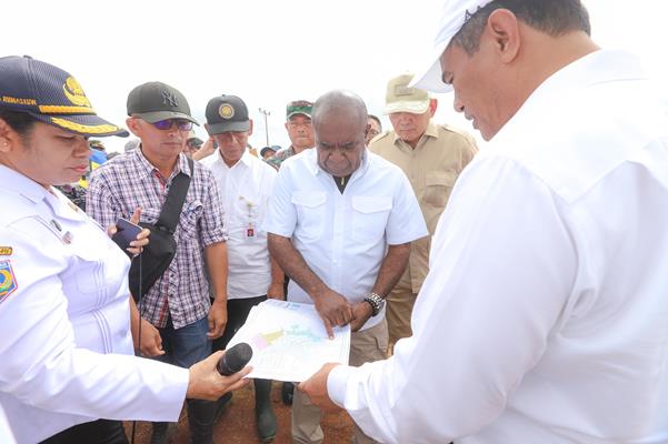 Menteri Pertanian RI, Amran Sulaiman  sedang menyaksikan dengan serius saat Bupati Merauke, Romanus Mbaraka menunjuk lokasi atau lahan pertanian yang digunakan – Surya Papua/IST