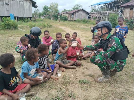 Puluhan anak sedang menikmati susu maupun telur dari Satgas Yonif 125-SMB – Surya Papua/IST