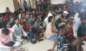 Ratusan masyarakat yang duduk di lantai dalam ruangan utama sidang DPRD Merauke saat melakukan aksi demonstrasi – Surya Papua/Frans Kobun
