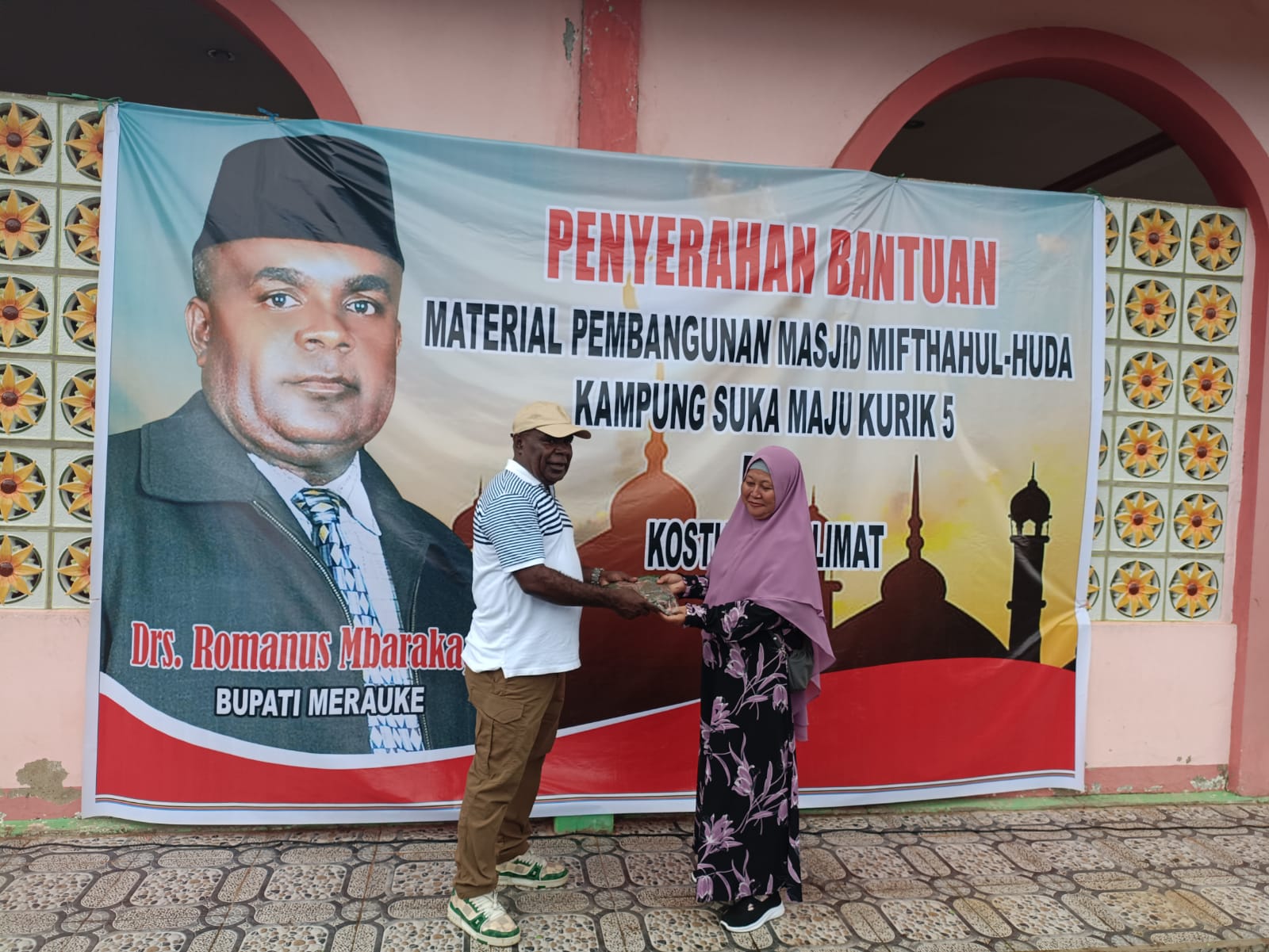 Salah seorag ibu perwakilan masjid menerima pakaian muslimah yang diserahkan Bupati Merauke, Romanus Mbaraka – Surya Papua/Frans Kobun