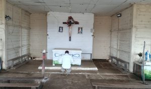 Bupati Merauke, Romanus Mbaraka sedang khusyuk berdoa di depan altar – Surya Papua/Frans Kobun