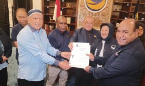 Penyerahan B1KWK kepada Bacabup-bacawabup Merauke, Yoseph Gebze-Fauzun Nihayah didampingi Ketua DPW Partai NasDem Provinsi Papua Selatan, Romanus Mbaraka – Surya Papua/Frans Kobun