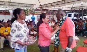 Perwakilan keluarga sopir sedang selendangkan Romanus Mbaraka dengan kain khas NTT – Surya Papua/Frans Kobun