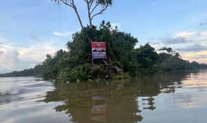 Sebuah baliho Romanus-Muyak yang dipasang dipasang di Kali Muara Edera – Surya Papua/IST