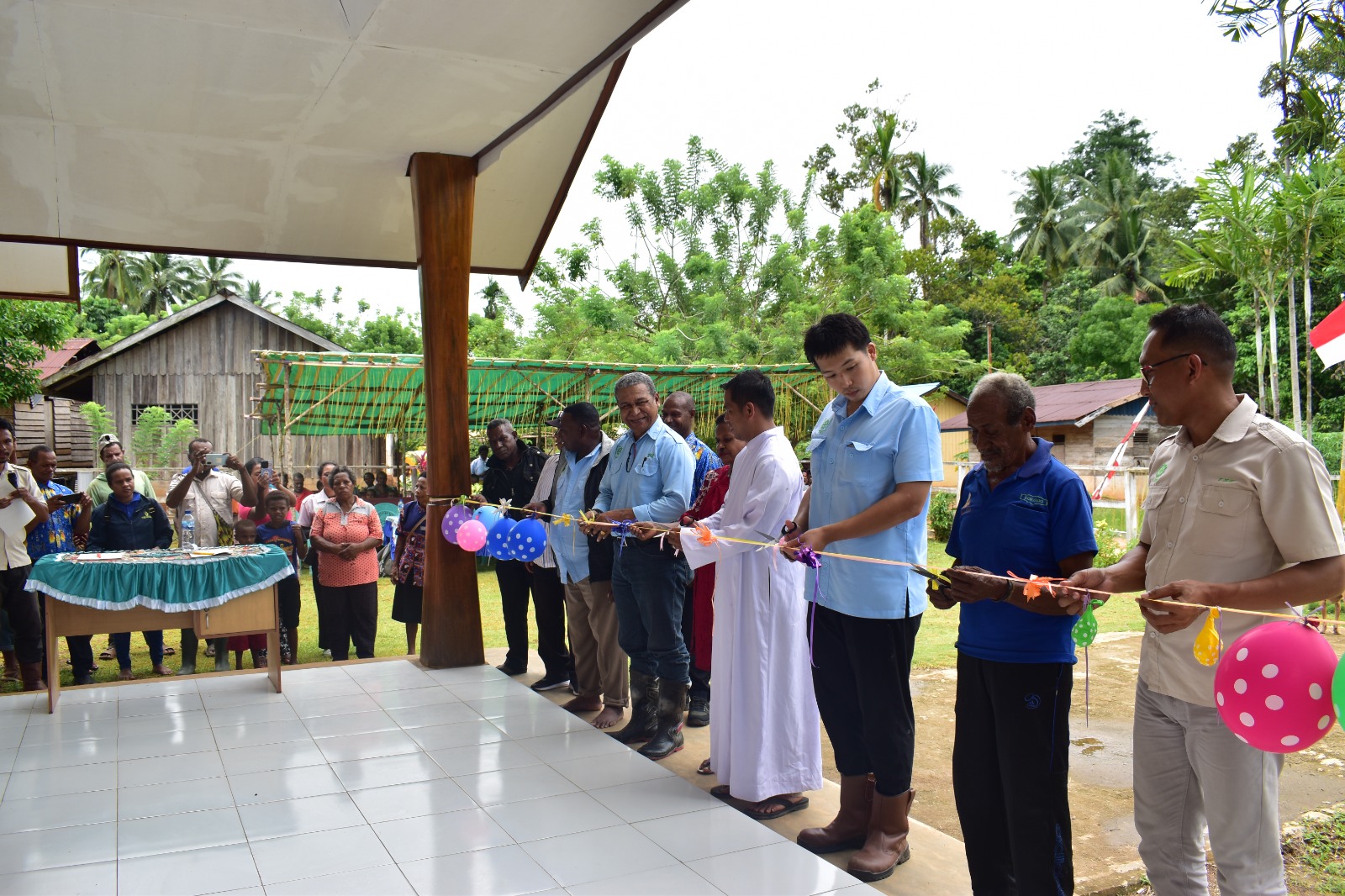 Pengguntingan pita oleh perwakilan TSE Group bersama Pastor Antonius serta perwakilan masyarakat – Surya Papua/IST