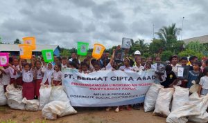 Foto bersama pihak perusahan serta para guru dann anak didik di SD YPK Selil usai pembersihan lingkungan sekolah – Surya Papua/IST