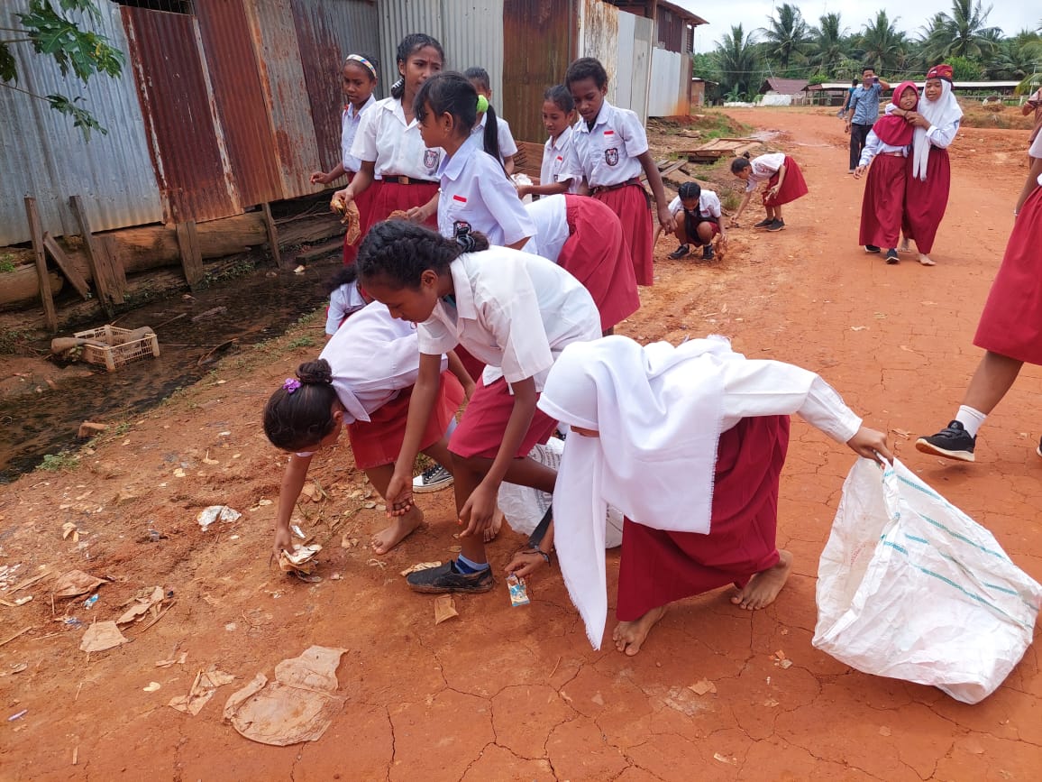 Sejumlah siswa-siswi SD YPK Selil sedang mengangkut sampah yang berserakan di sekitar halaman sekolah – Surya Papua/IST