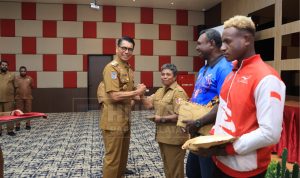 Penjabat Gubernur Papua Selatan, Rudy Sufahriadi sedang menyerahkan bantuan dana kepada atlet dan pelatih – Surya Papua/IST