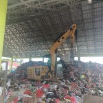 Exavator mini yang digunakan untuk mengangkut sampah ke dalam mobil – Surya Papua/Frans Kobun