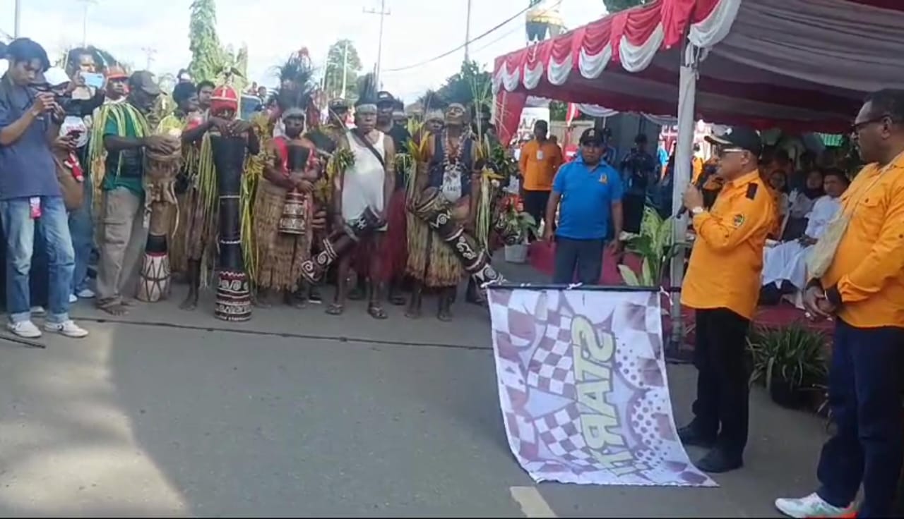 Wakil Bupati Merauke, H. Riduwan saat mengangkat bendera sekaligus melepas peserta karnaval – Surya Papua/Frans Kobun