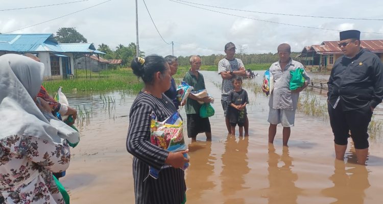 Anggota DPD RI, Gus Adib Fuad saat bersama masyarakat Kampung Sumber Rejeki di dalam genangan banjir – Surya Papua/Frans Kobun