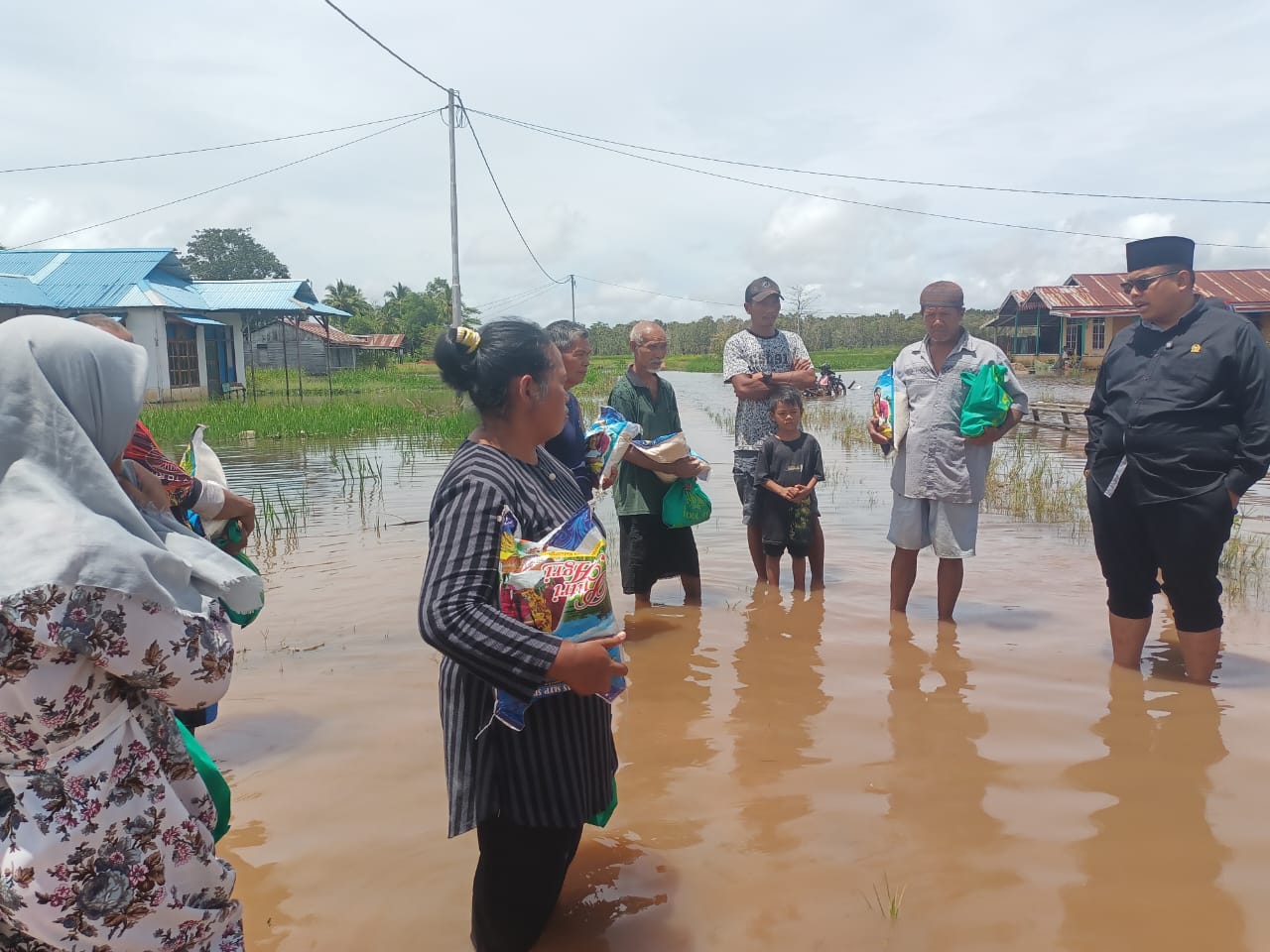 Anggota DPD RI, Gus Adib Fuad saat bersama masyarakat Kampung Sumber Rejeki di dalam genangan banjir – Surya Papua/Frans Kobun