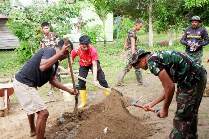 Salah seorang prajurit TNI bersama sejumlah warga sedang membalik campuran – Surya Papua/IST