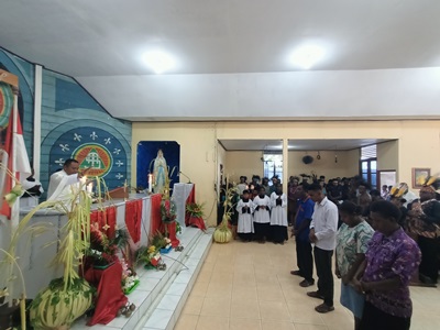 Dua orang yang sedang mengucapkan ikrar di depan altar sekaligus menyatakan bergabung ke Gereja Katolik – Surya Papua/Frans Kobun
