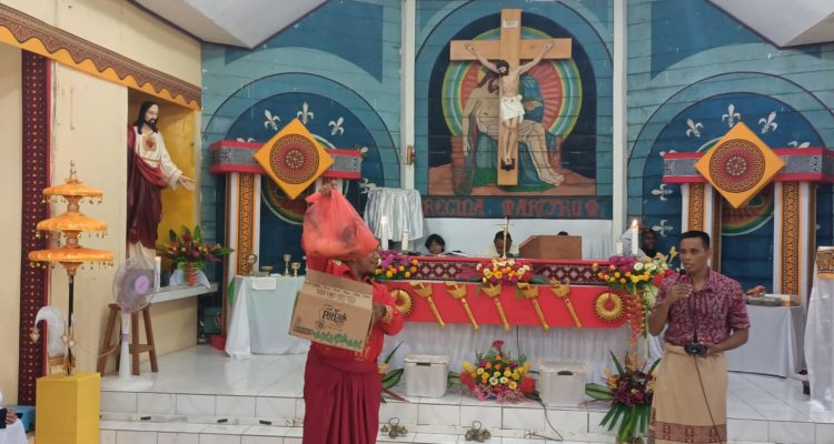 Kepala babi sedang dilelang dalam perayaan misa Inkulturasi Toraja di Gereja Santa Theresia Buti – Surya Papua/Frans Kobun