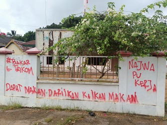Coretan di pagar tembok Kantor Telkom Merauke dengan menyertakan nama Najwa juga – Surya Papua/Frans Kobun