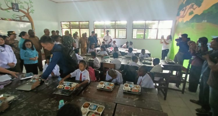 Anak-anak di SD Gudang Arang Merauke sedang menikmati makan bergizi gratis (MBG) – Surya Papua/Frans Kobun